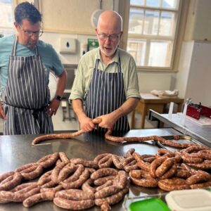 The product of my endeavours - endless links of handmade sausages at the Artisan School of Food, pictured with my tutor and a fellow participant